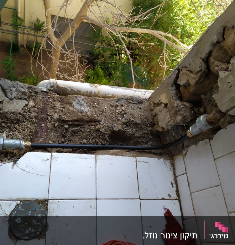 צינור מים ותשתית חשופה בקיר שבור